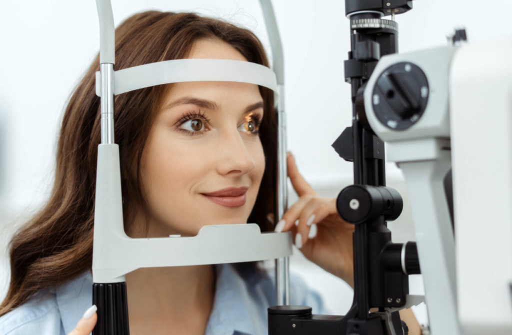 A female patient has her eyes examined by an optometrist using a slit lamp